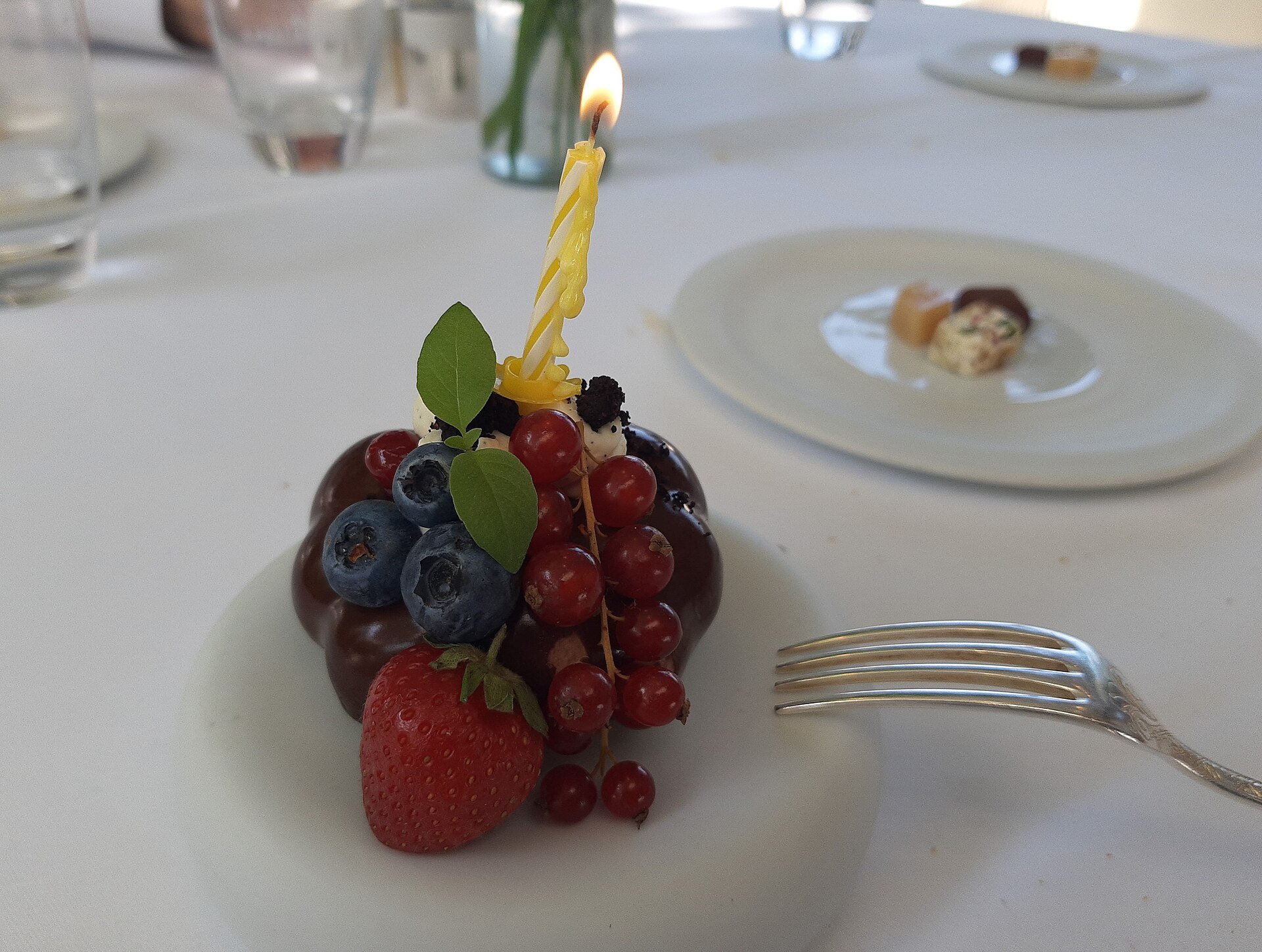 Bolinho de chocolate com frutas vermelhas e vela acesa