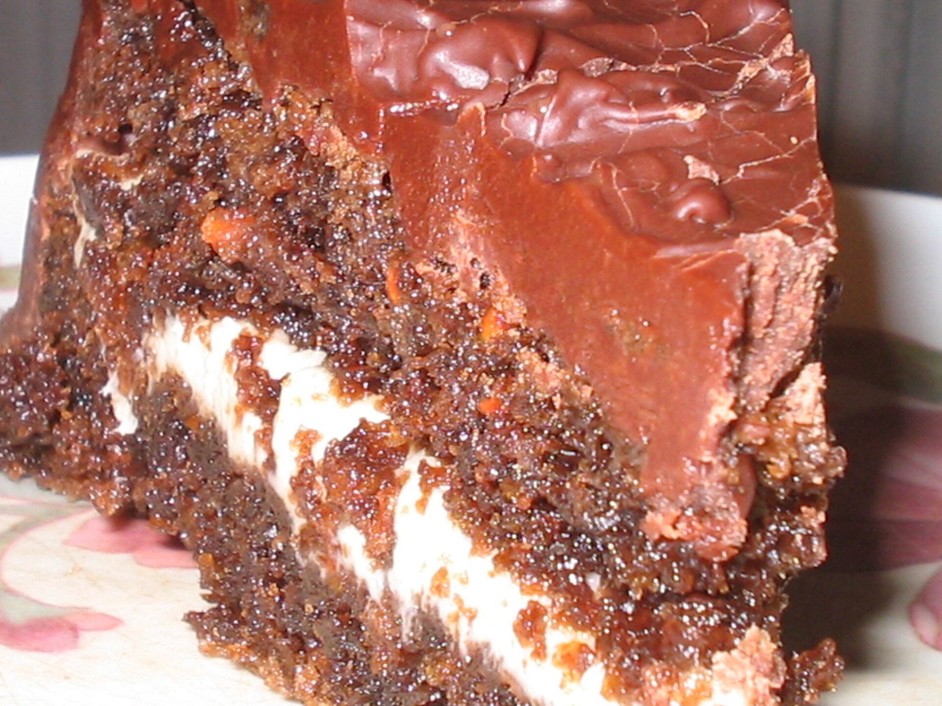 Fatia de bolo de chocolate com recheio branco e cobertura